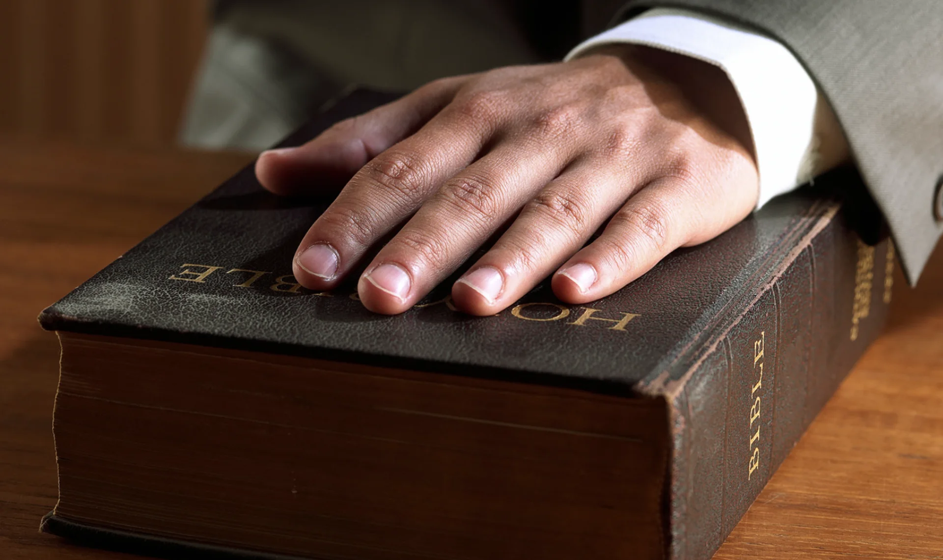 Hand placed on Bible symbolizing an expert witness swearing an oath in court