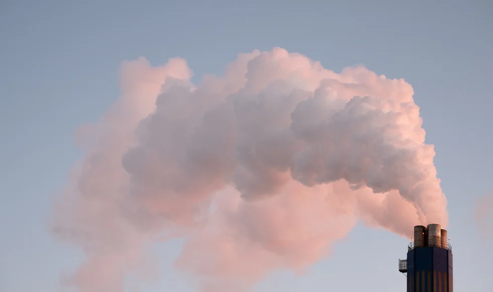 A smokestack releasing thick clouds of emissions into the sky, representing industrial air pollution and toxic exposure risks.
