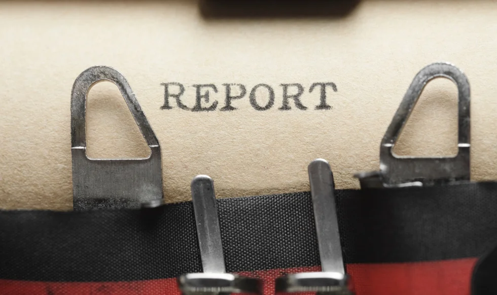 Close-up of the word 'Report' typed on paper in a typewriter