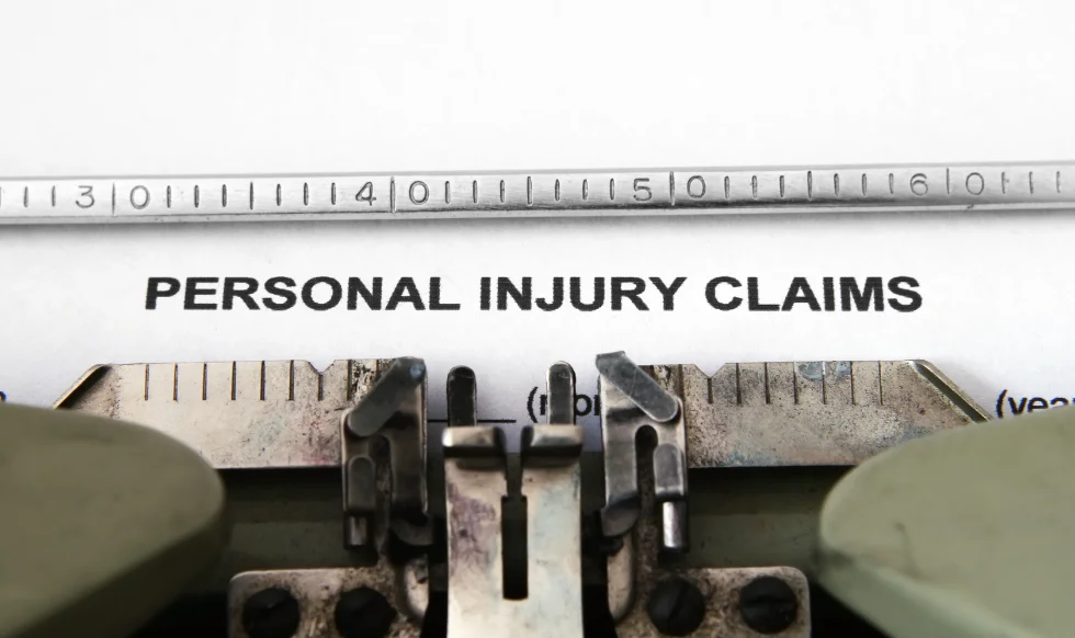 Typed words “Personal Injury Claims” on paper in a typewriter, symbolizing legal documentation for accident-related expenses